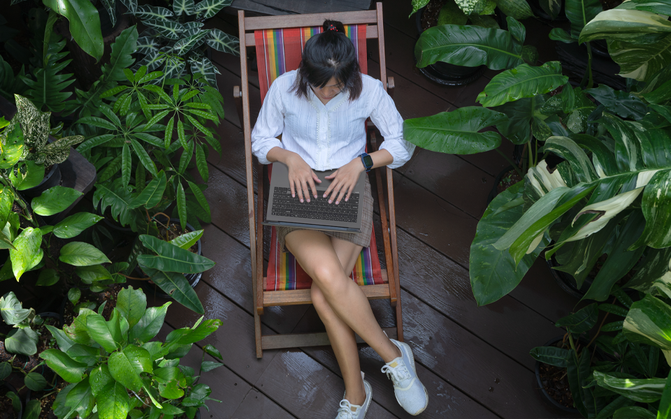 LG consumer using their laptop surrounded by nature-inspired background, promoting sustainable living.