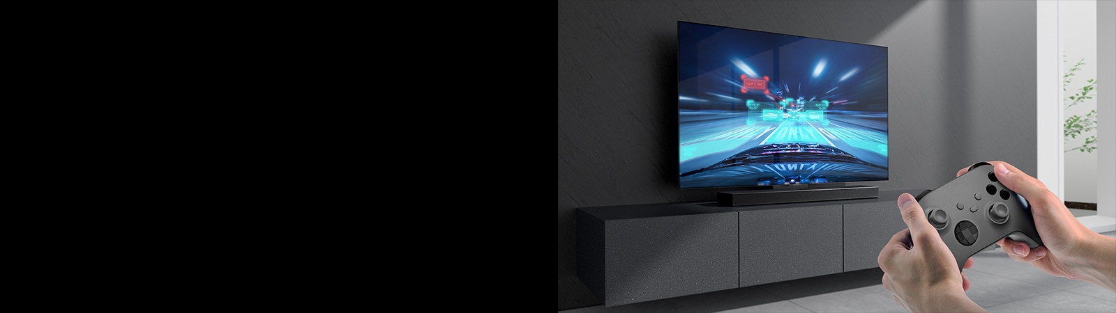 Sound Bar zvu?nik na elementu i scena iz trka?ke igre na televizoru povezanom sa Sound Bar zvu?nikom. Igra?ka konzola se nalazi u donjem desnom uglu slike i dr?e je dve ruke.