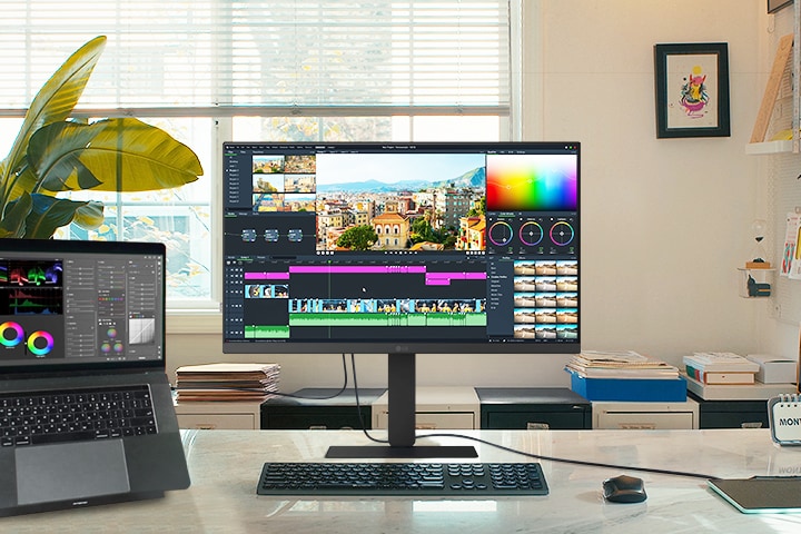 Kreativan radni prostor s LG monitorom i povezanim laptopom. Na oba je interfejs za monta?u videa s alatkama za gradaciju boja i vremenskom osom.	