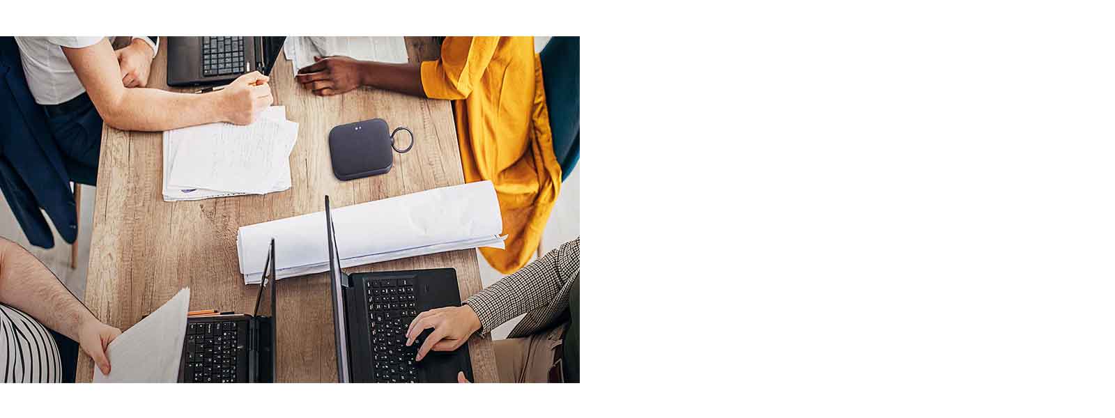 4 osobe rade za stolom, svaka na svom laptopu. Lica nisu prikazana, neki kucaju, neki pi?u. XBOOM Go PN1 zvu?nik se postavlja na sto.