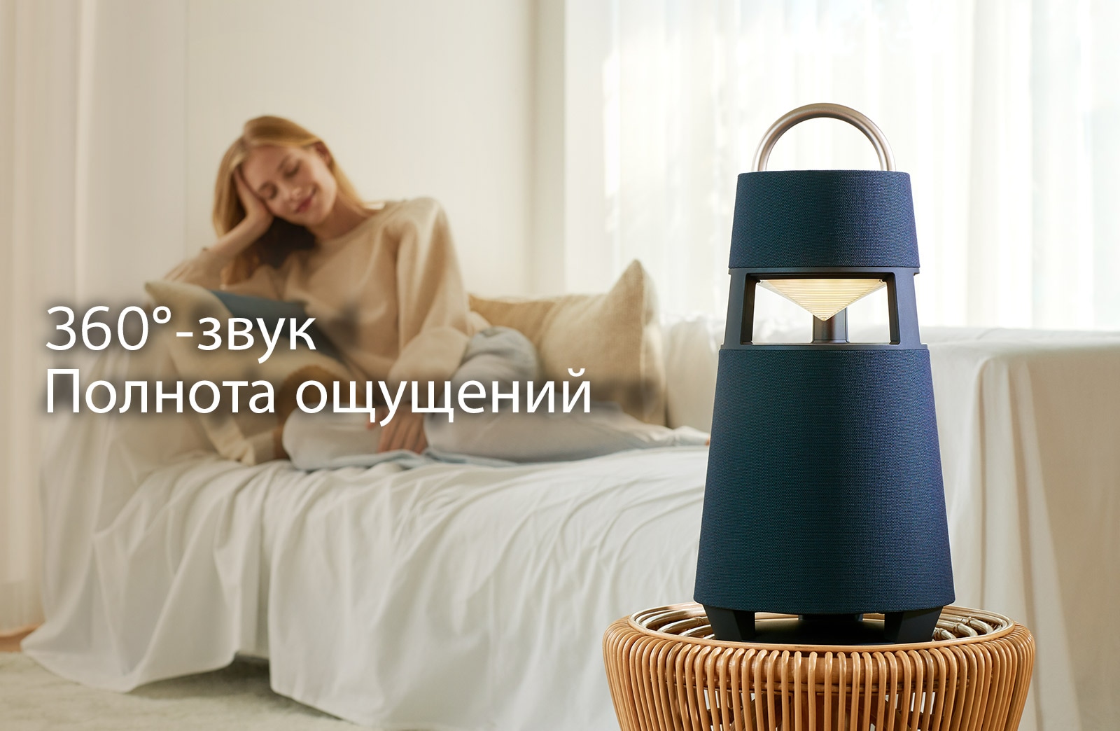 Изображение женщины, сидящей на диване и слушающей музыку с XBOOM 360 на переднем плане