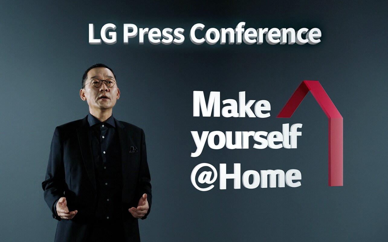 Мужчина в черном костюме произносит речь о функции LG ThinQ ?сделай себя как дома? на пресс-конференции LG.