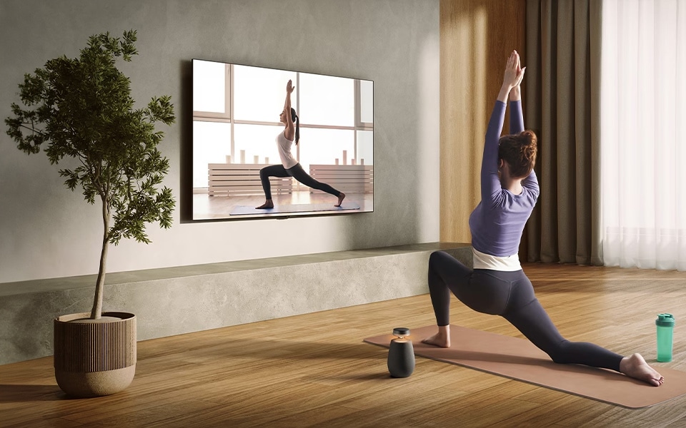 woman performing yoga with LG XBOOM 360 portable, bluetooth, wireless speakers with surround sound system