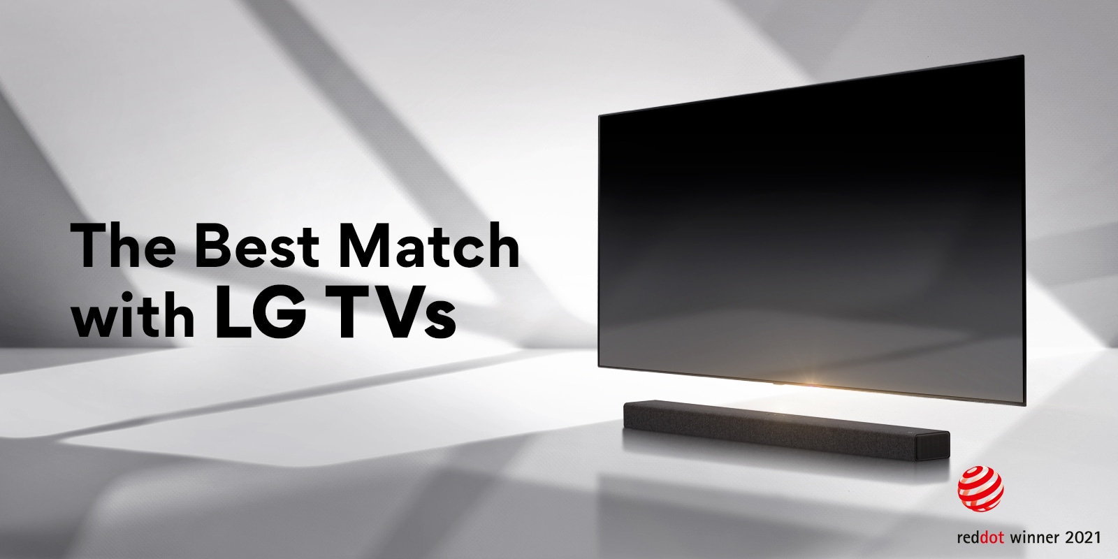 A soundbar and a TV are placed on a white floor and there is a shadow coming from outside right behind. Reddot award logo is placed right next to soundbar.