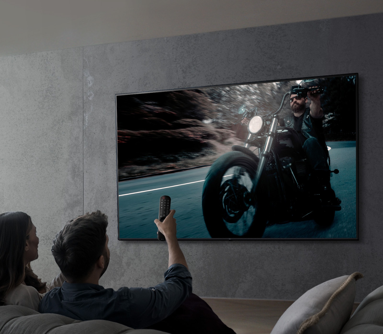 Na obrázku je pár, ktory na televízore LG s rozlí?ením UHD sleduje program.