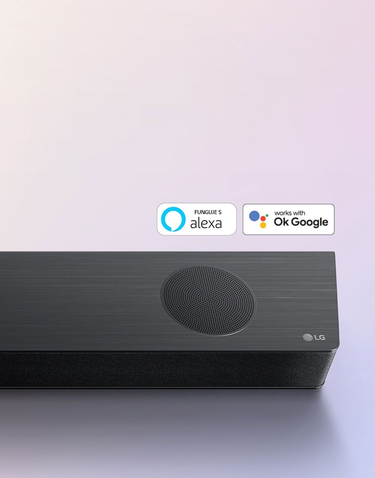 Zvukovy panel LG je umiestneny na zemi a zobrazuje logo LG v pravom rohu panelu. Na zvukovom paneli sú umiestnené logá Alexa a OK GOOGLE.