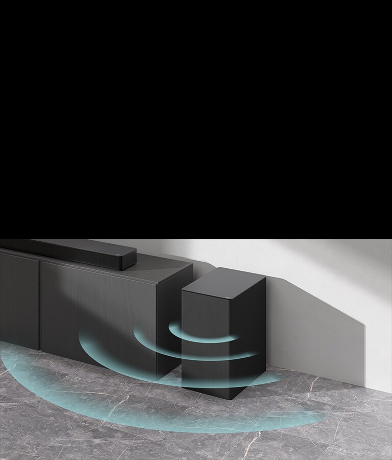 Zvukovy panel je polo?eny na skrinke. Ved?a na zemi je polo?eny bezdr?tovy subwoofer. Zo subwoofera vychádza modrá zvuková grafika.