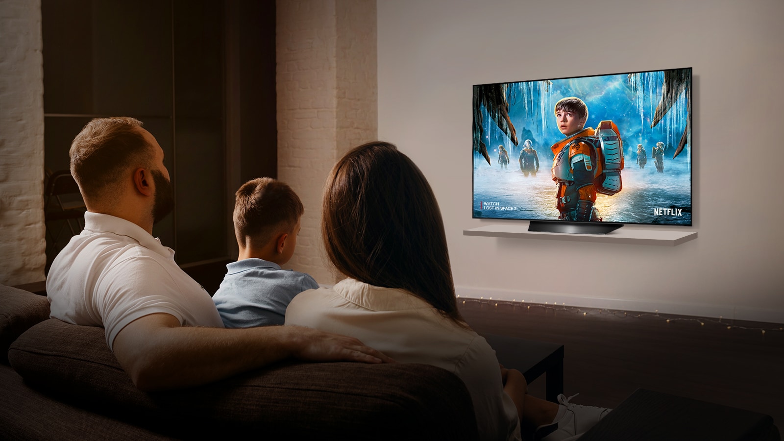 Pár sediaci na pohovke v obyvacej izbe sleduje na televízore romanticky film