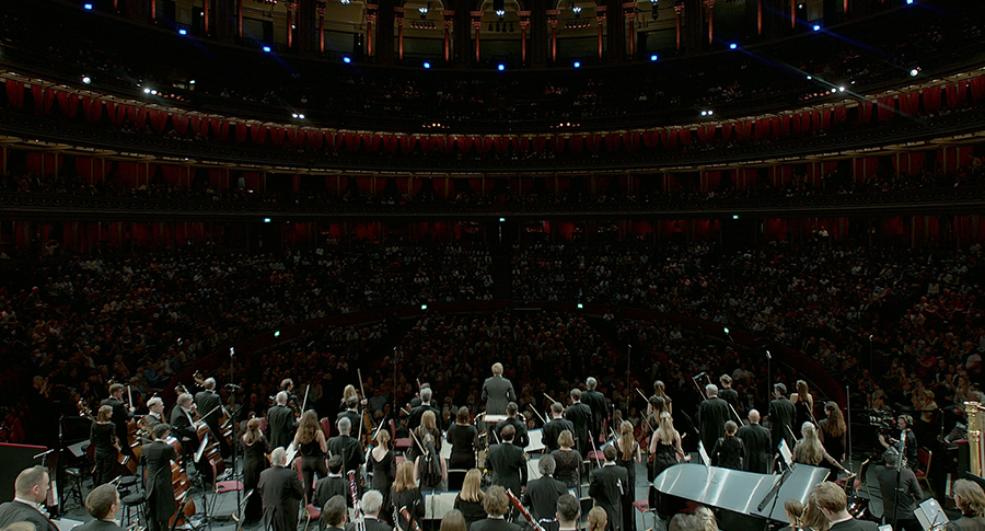 A full grand orchestra performs in a large theater