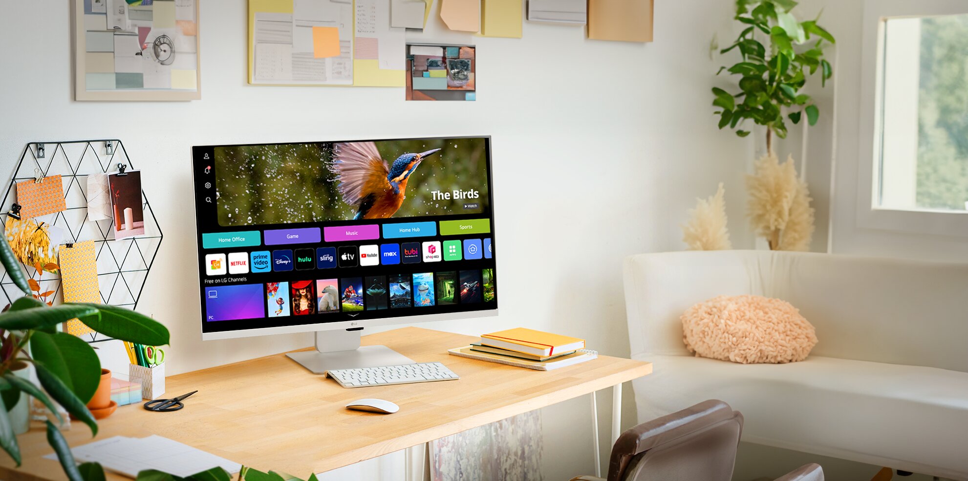 LG Smart Monitor on a wooden desk in a bright, plant-filled home office.