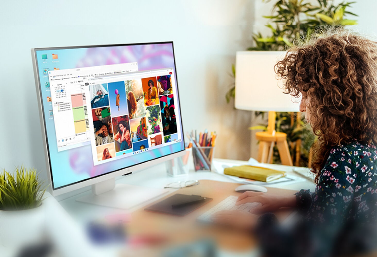 A young woman is hard at work, typing on her keyboard in front of her LG MyView Smart Monitor.