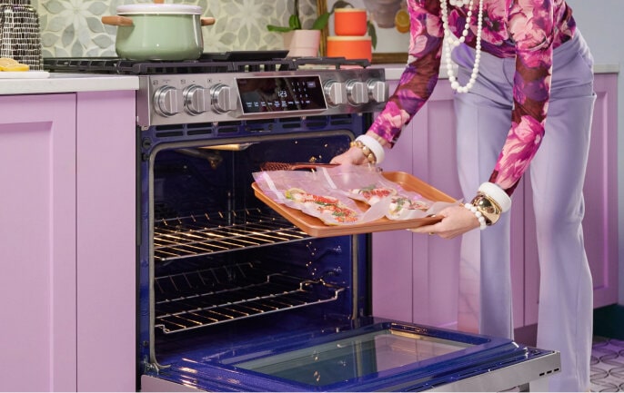 Person placing food inside the LG Studio oven for Air Sous Vide cooking, ensuring precise temperature control.