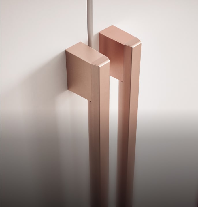 Elegant light bronze handles on LG Studio refrigerator with charcoal gray interior.