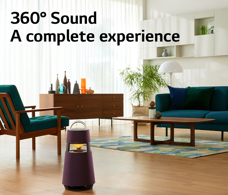 Divanda o?tirib XBOOM 360 karnayida musiqa tinglayotgan ayol surati