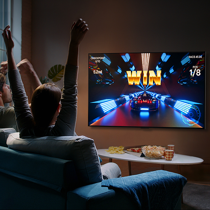 Odamlar kontroller yordamida LG OLED televizorida o?yin o?ynamoqdalar